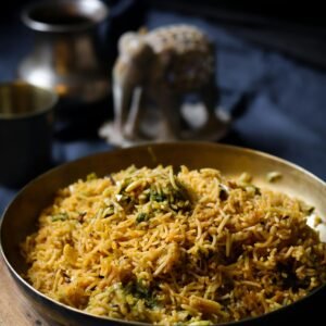 Delicious Indian biryani served in a traditional setting with a decorative elephant statue.
