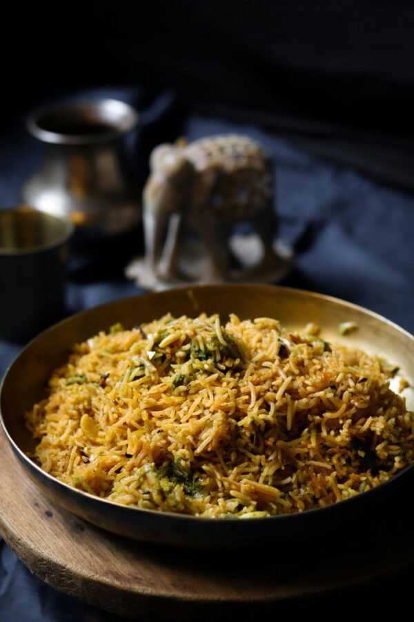 Delicious Indian biryani served in a traditional setting with a decorative elephant statue.